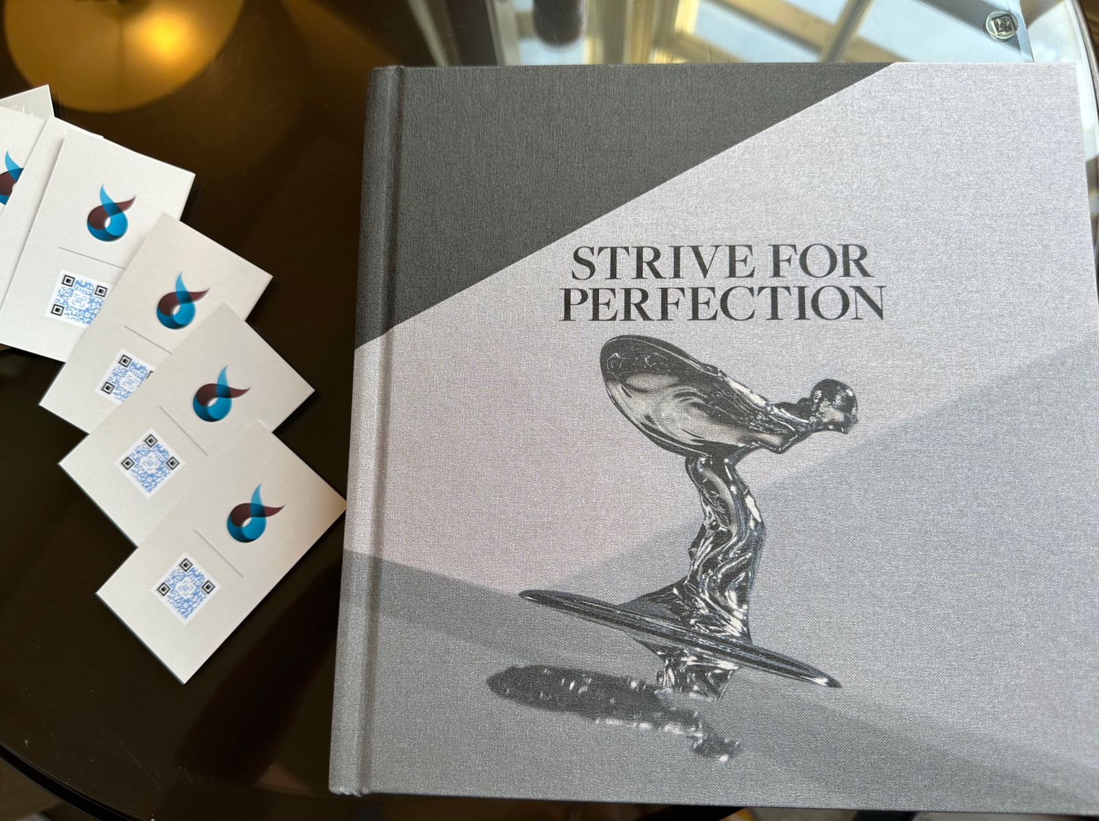 erosantorini business cards - strive for perfection goodwood book - grosvenor house